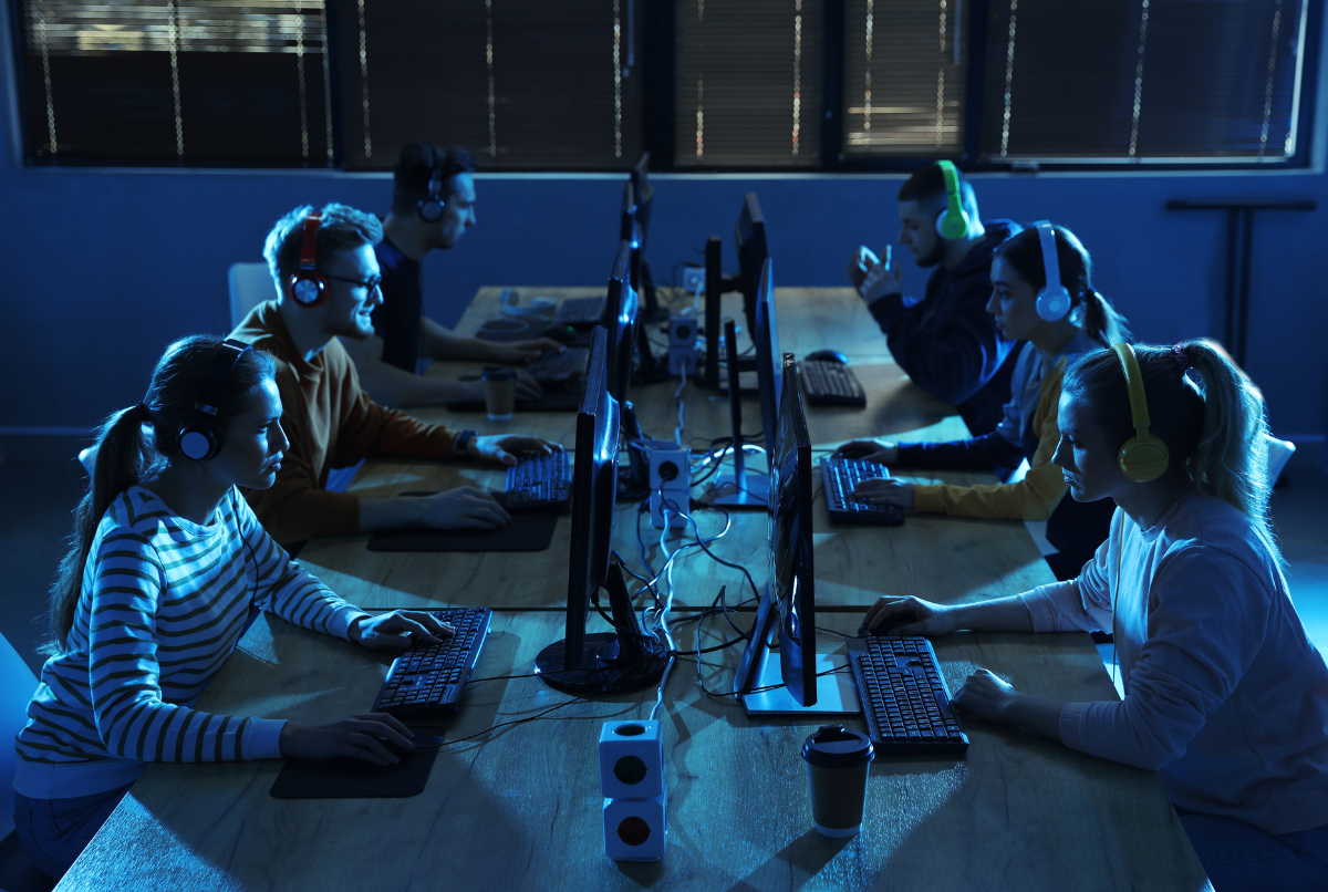 Tim gamer e-sports di ruang neon memantau layar FPS tinggi di PC rakitan